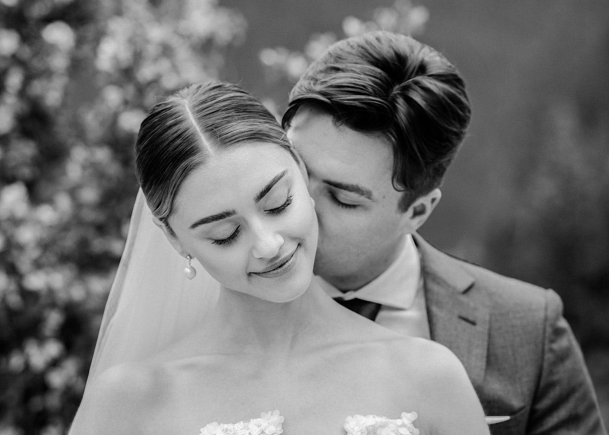 Intimate moment with groom kissing bride’s neck, capturing Riga wedding emotions