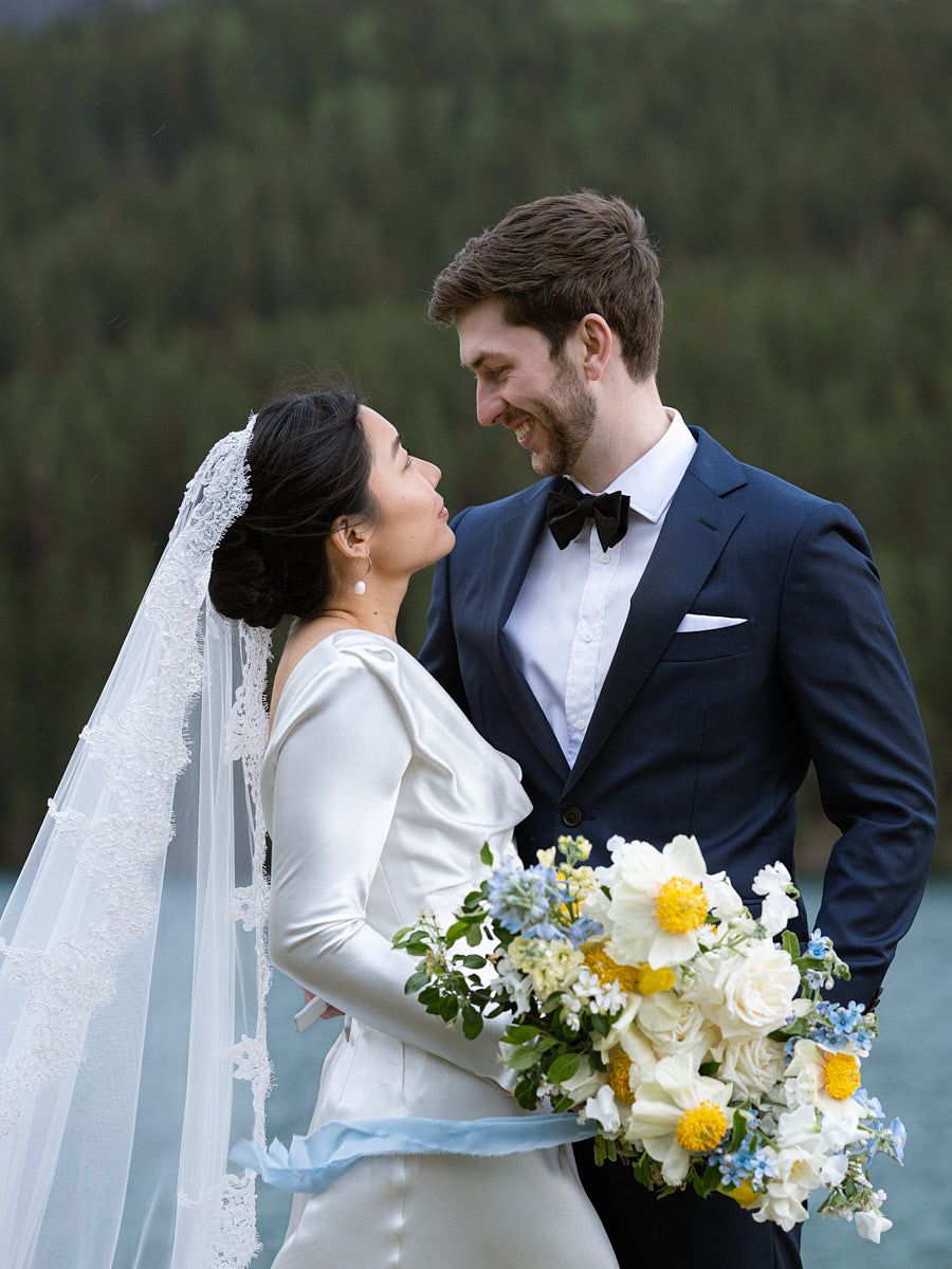 Outdoor wedding portrait of couple enjoying quiet lake and woodland scenery