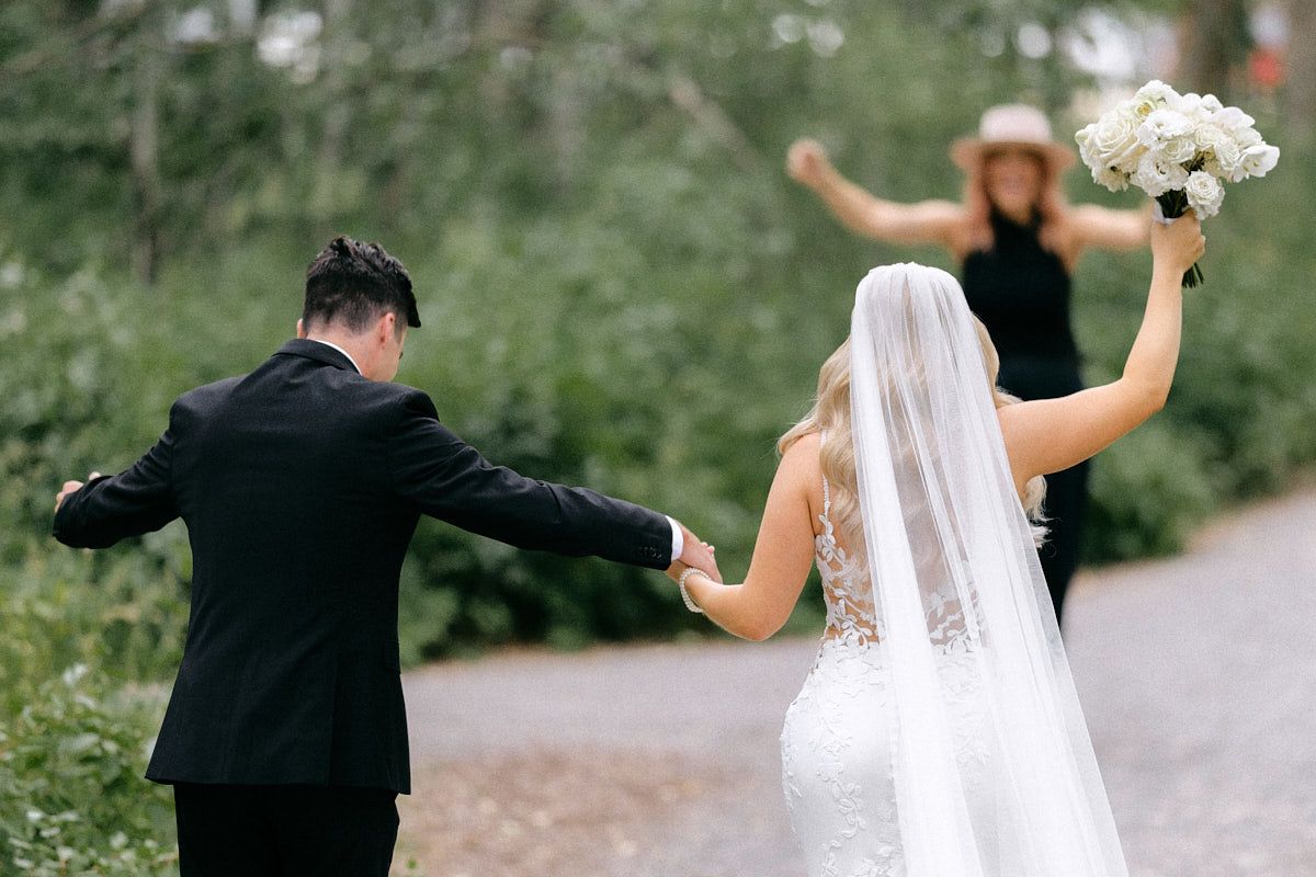 Joyful bride and groom running to wedding planner after ceremony, capturing fun Riga wedding moments