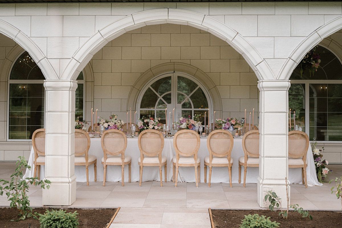 Romantic pastel-coloured table decor with cutlery, plates, and floral arrangements
