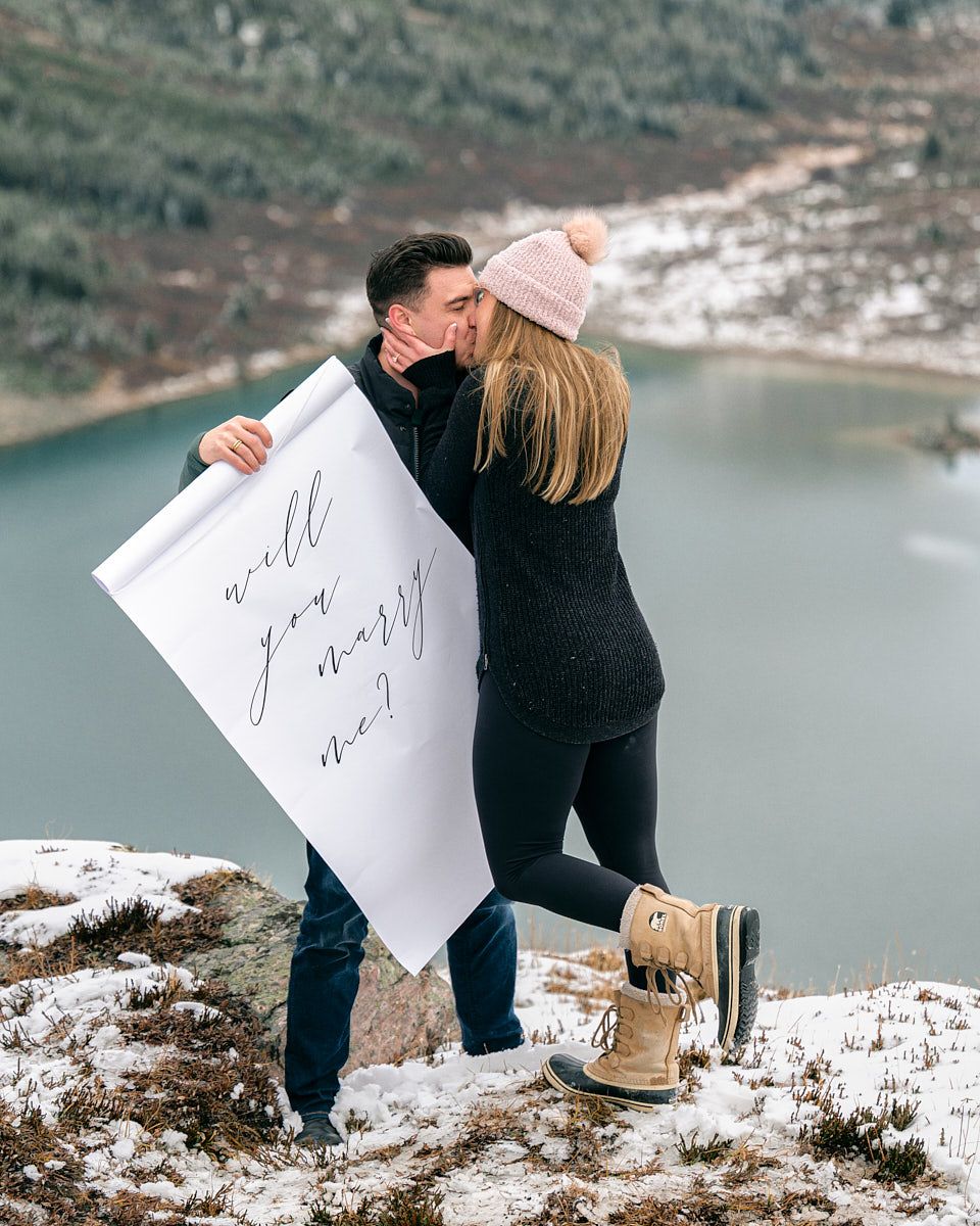 Proposal with “Will you marry me” scroll in scenic mountain engagement session in Europe