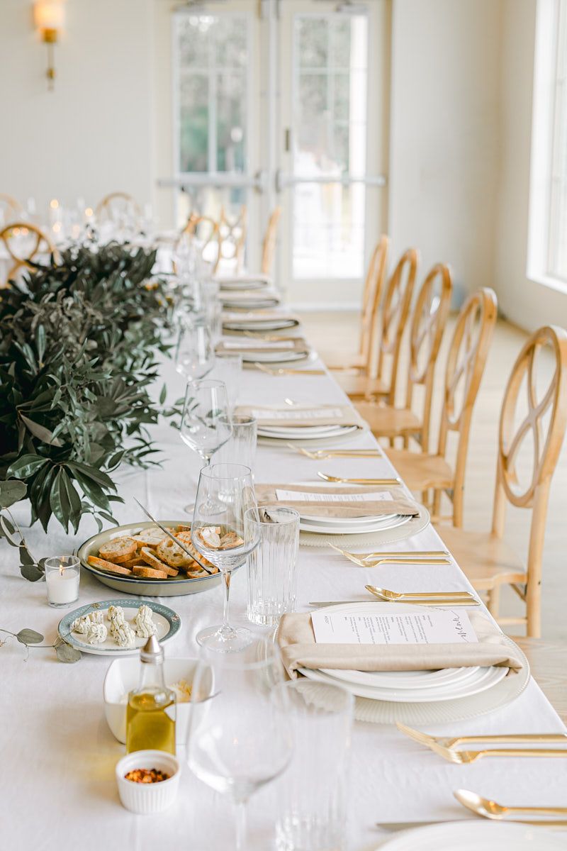 Elegant wedding table setting with plate, utensils, and green floral decor, ideal for Riga receptions