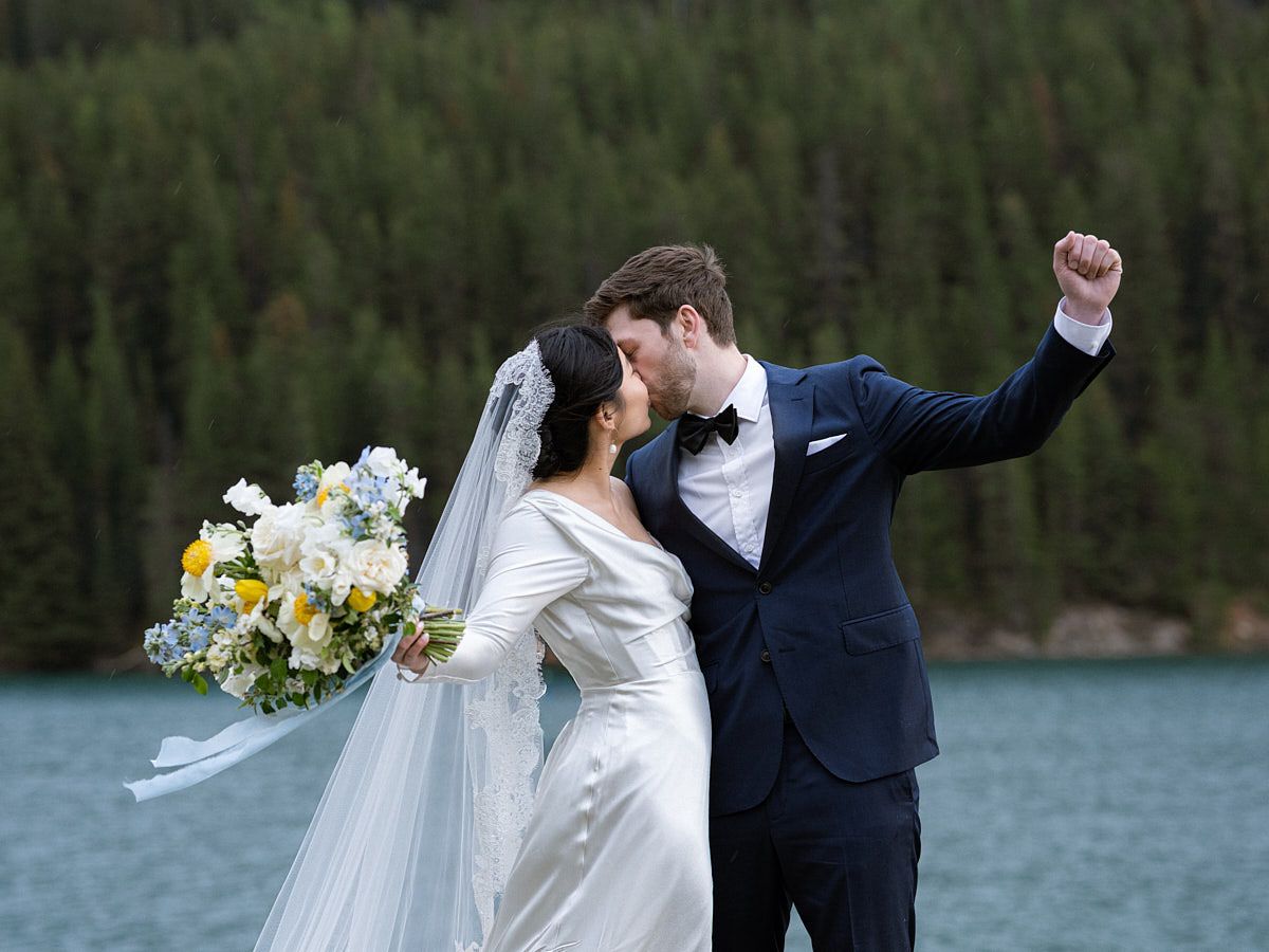 Bride and groom embracing by a serene forest lake, perfect European wedding inspiration
