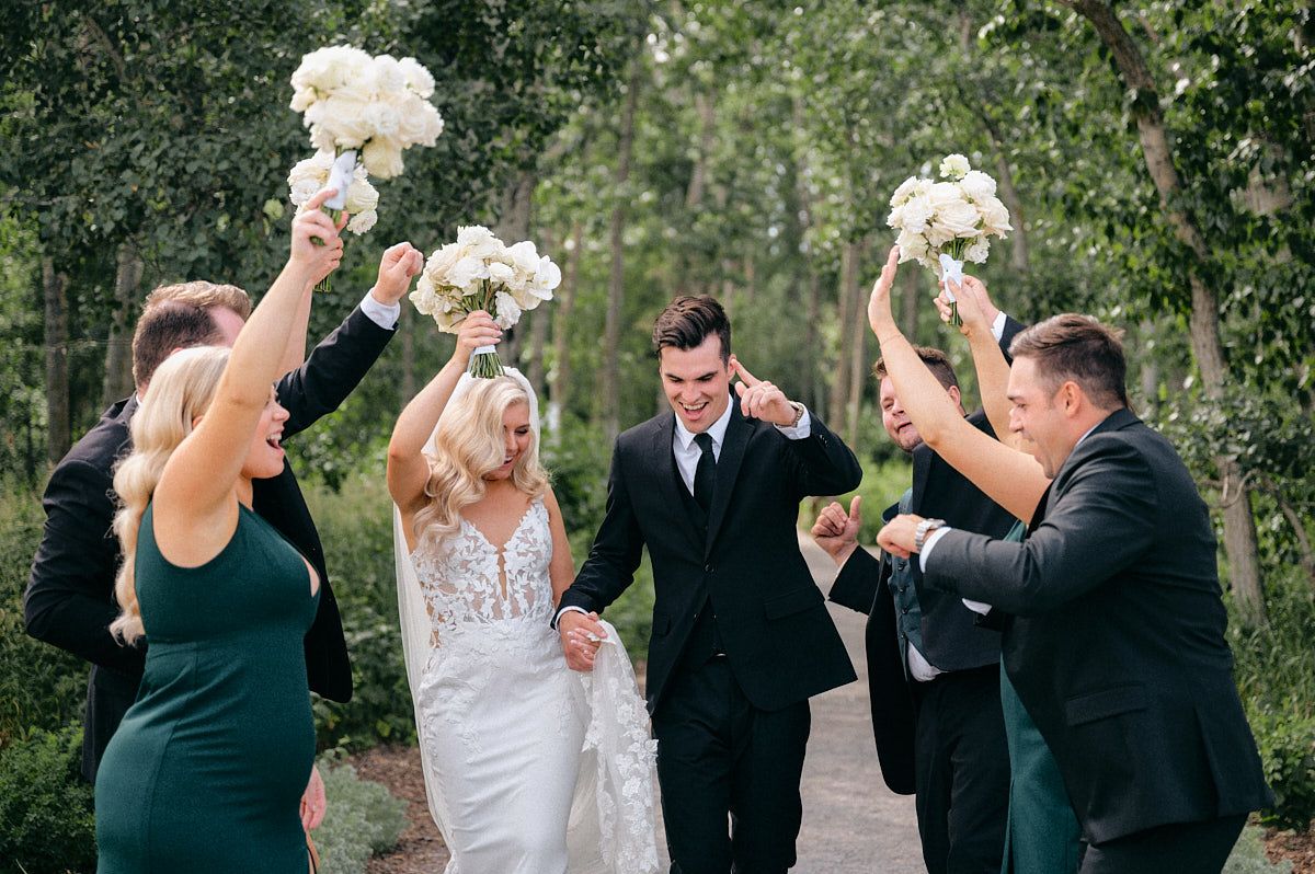 The bride, groom, and their wedding party pose together, celebrating their special day at a Latvian wedding venue