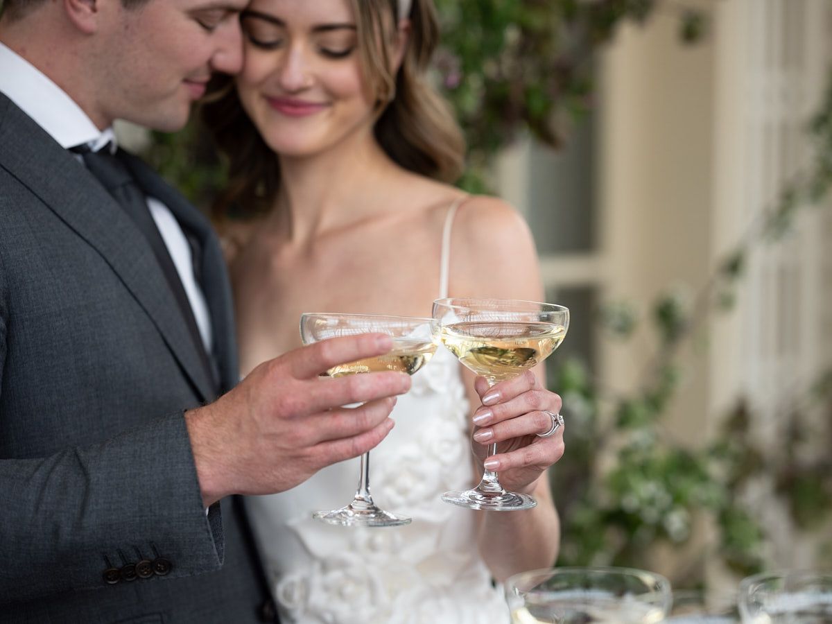Couple toasting with champagne in front of wedding tower in Riga