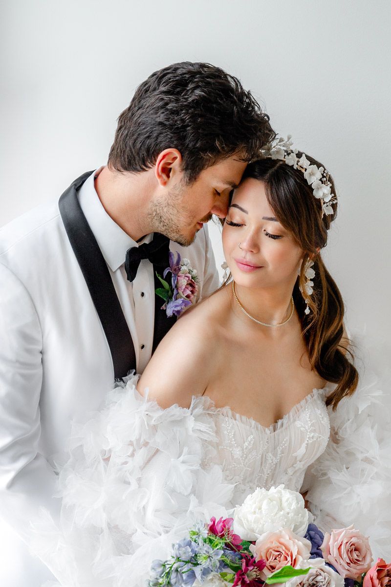 Bride and groom nuzzling lovingly on their wedding day in Riga, captured in an intimate and timeless photograph.