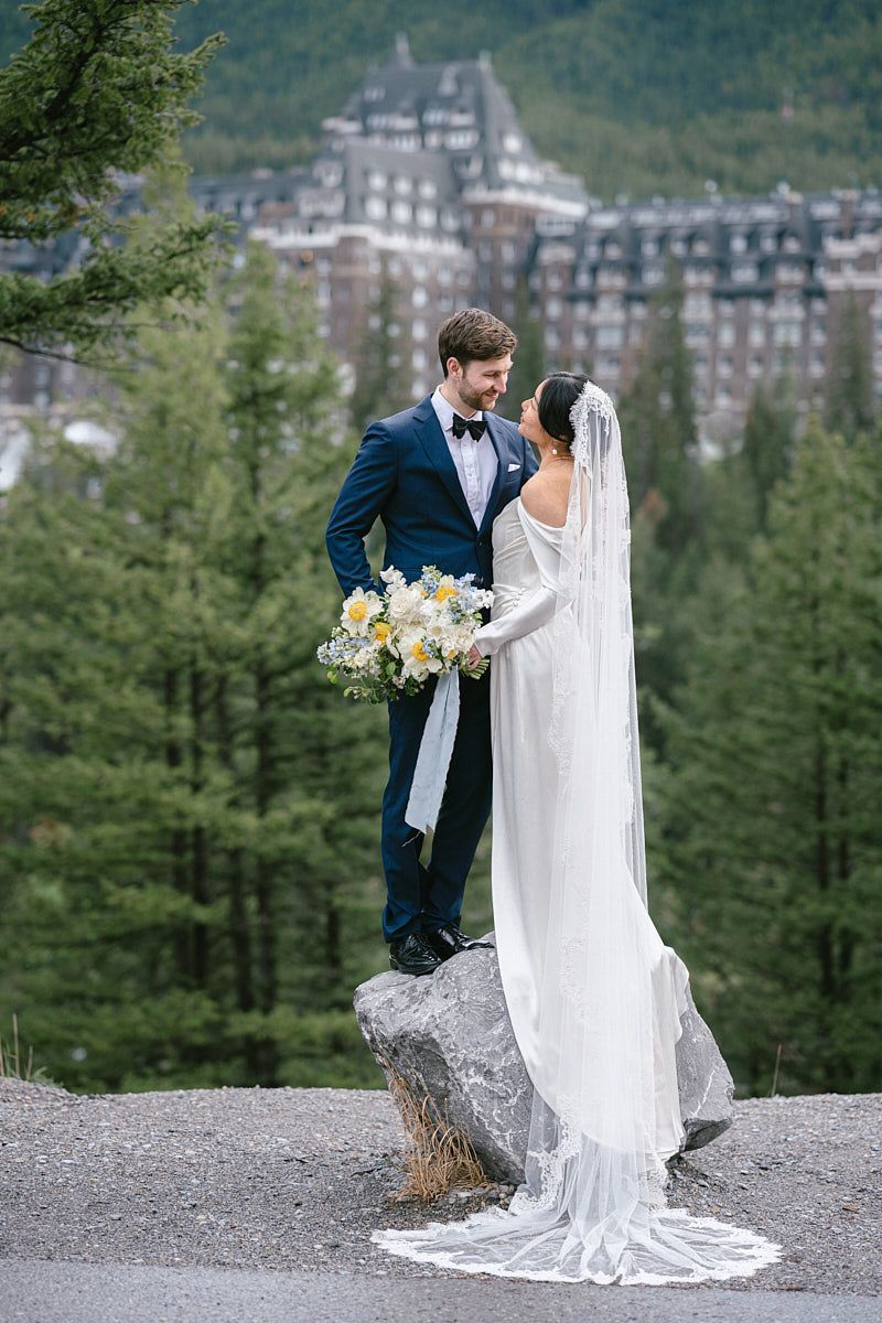 Outdoor wedding portrait of couple near a majestic castle in the forest