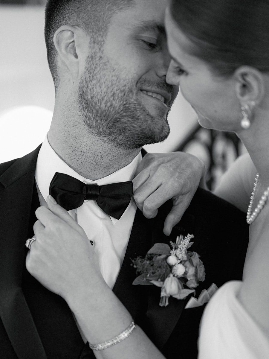 Intimate Riga wedding moment as bride lovingly fixes groom’s bowtie and shares a kiss