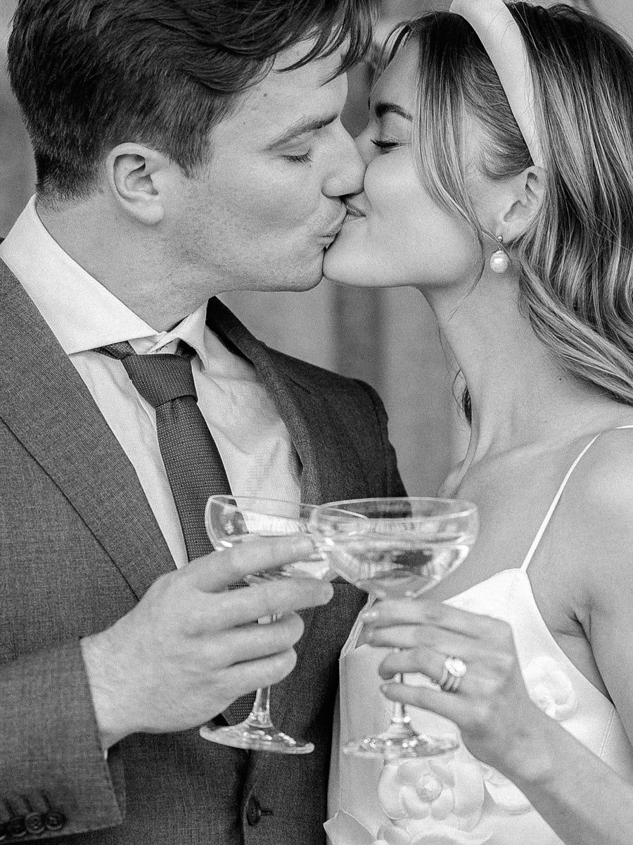 Couple toasting with champagne in front of wedding tower in Riga