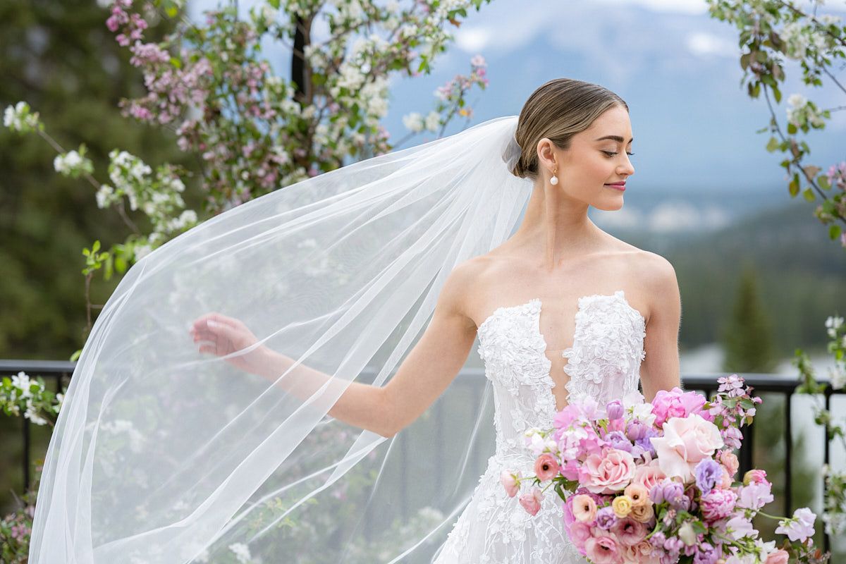 Playful bridal portrait with bride adjusting veil, captured in soft Riga wedding light
