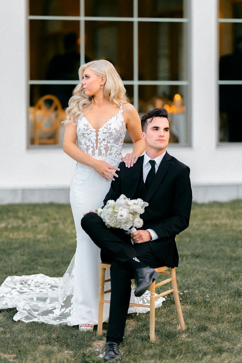 A stunning wedding portrait of the bride and groom with Sparrow Lane’s reception window in the background in Latvia