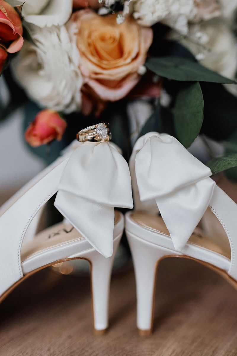 Wedding rings resting on TAXI bridal shoes, modern Riga wedding detail