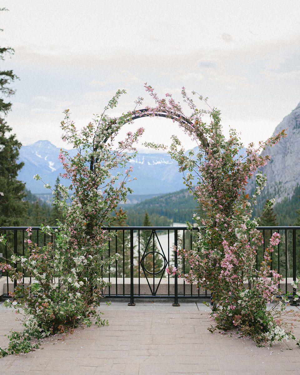 Wedding floral arch set against scenic European mountains, ideal for Riga wedding inspiration