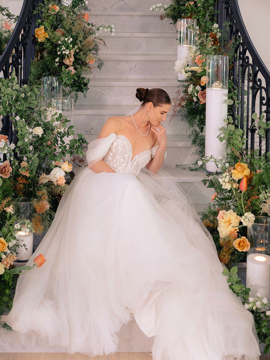 Bridal portrait on elegant Riga stairs, highlighting gown details and wedding style