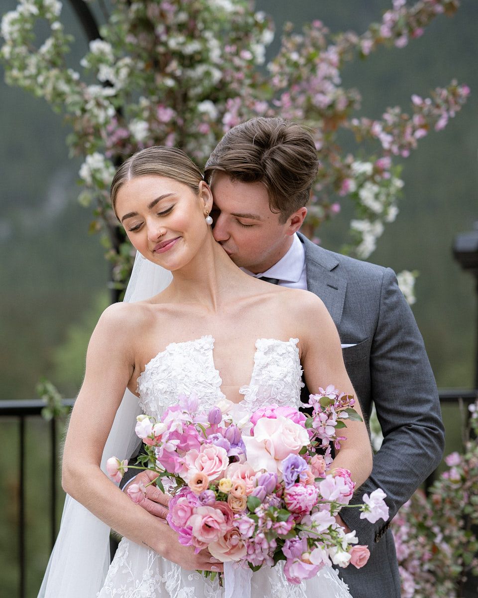 Romantic moment with groom kissing bride’s neck, capturing intimate Riga wedding emotions