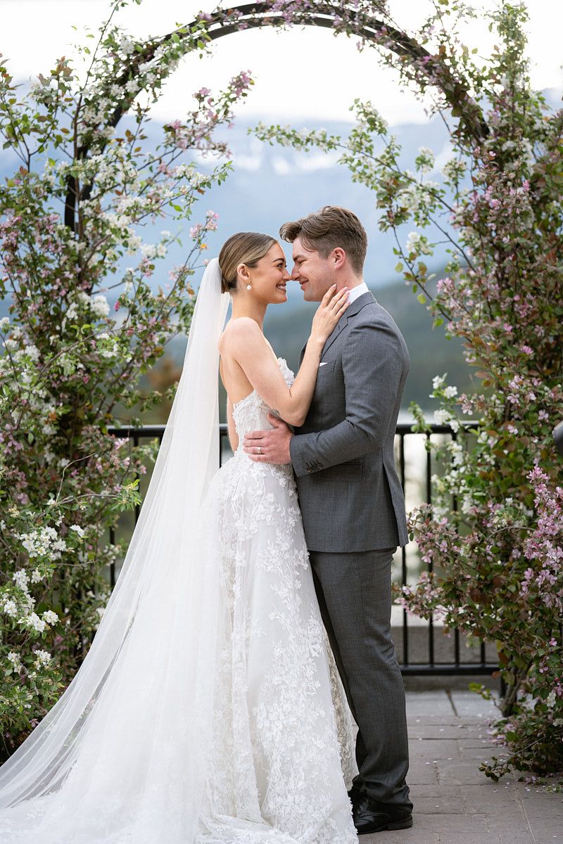 Bride and groom under a floral wedding arch, capturing elegant Riga ceremony moments
