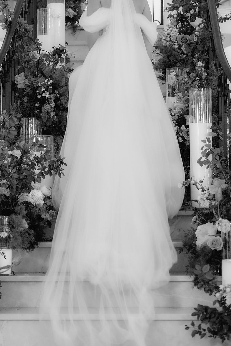 Flowing bridal gown captured while running up stairs, dynamic wedding moment in Riga venue