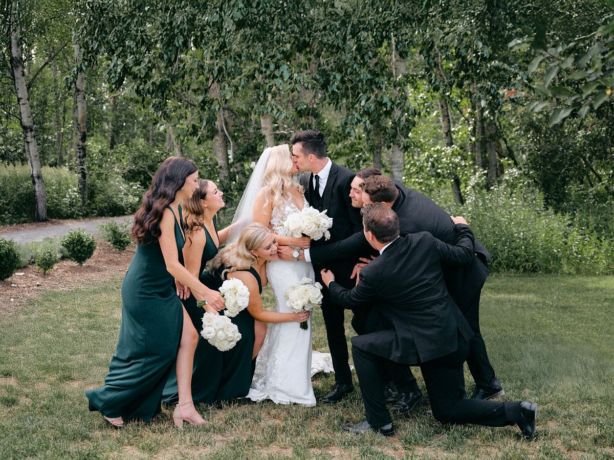 The bride, groom, and their wedding party pose together, celebrating their special day at a Latvian wedding venue