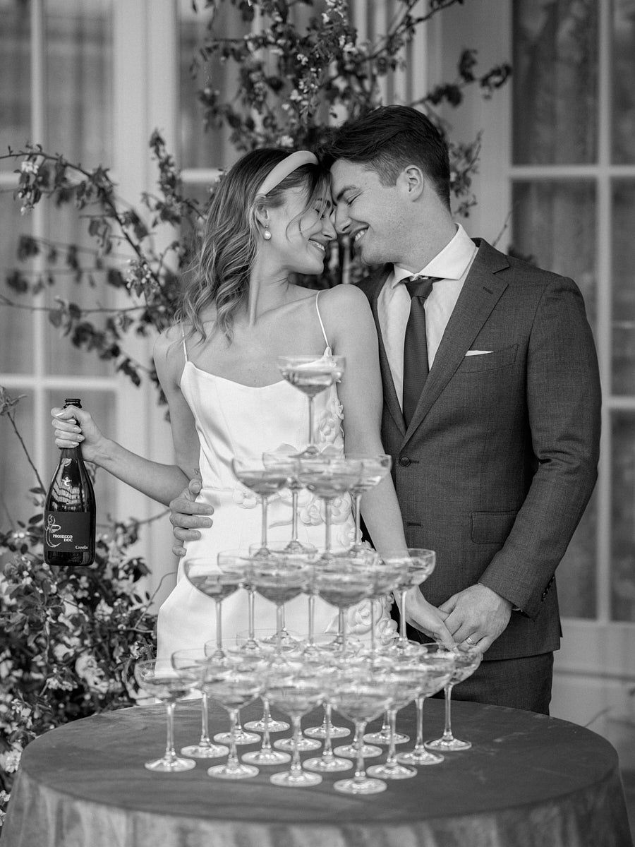 Bride and groom enjoying champagne at Riga wedding with glass tower