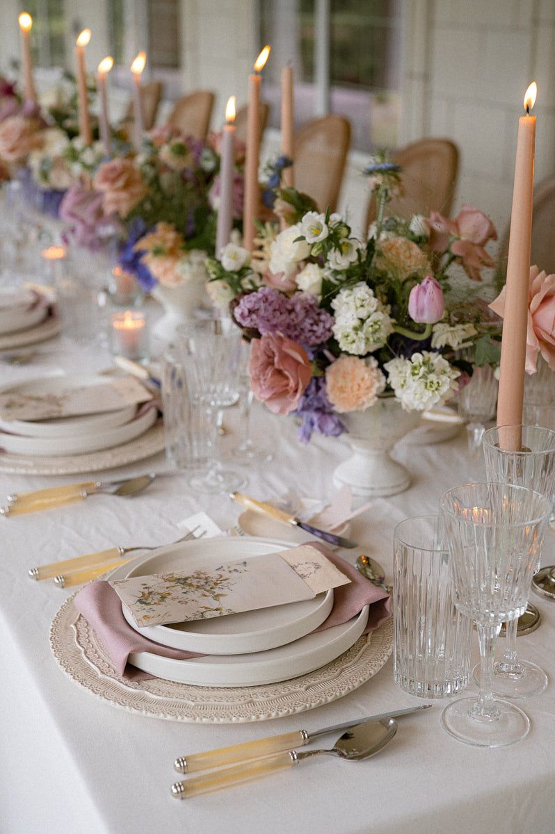 Scandinavian-inspired pastel wedding table setup with flowers and glassware