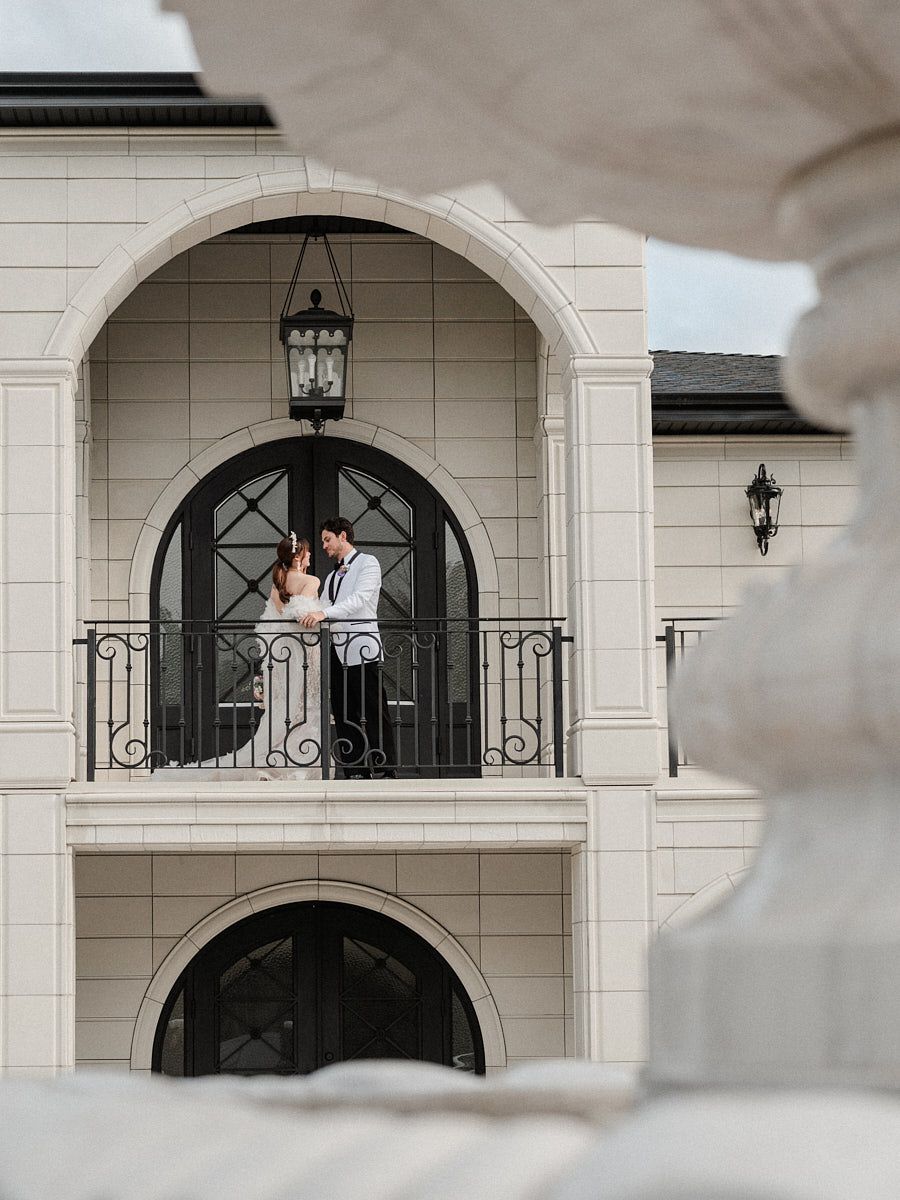 Romantic bride and groom sharing a quiet moment on manor balcony, perfect for Riga wedding photography