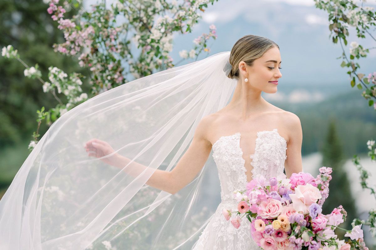Bride playfully arranging her veil, whimsical Riga wedding portrait in natural light