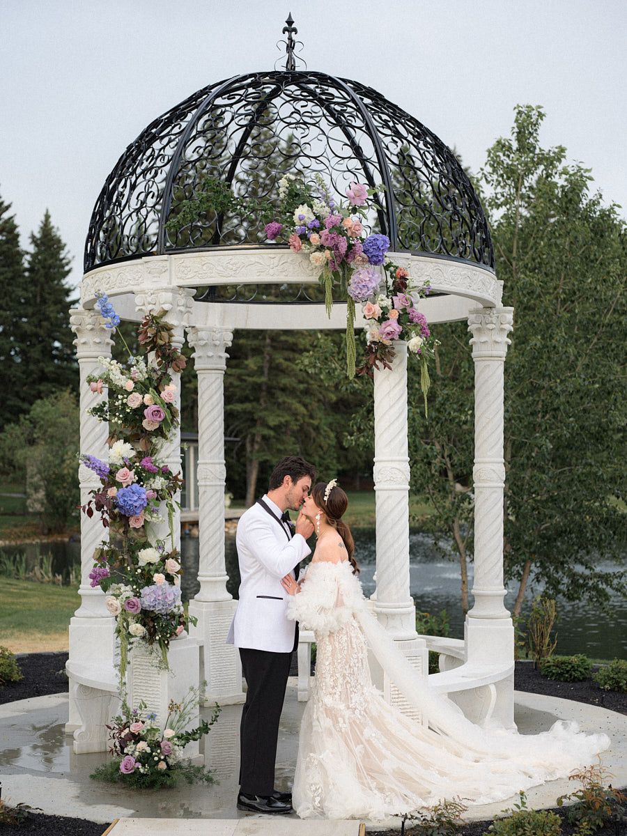 Bride and groom wedding ceremony in floral-decorated gazebo, capturing elegant Riga outdoor celebration