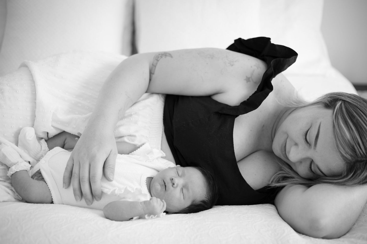 Black and white portrait of mother and baby resting together.