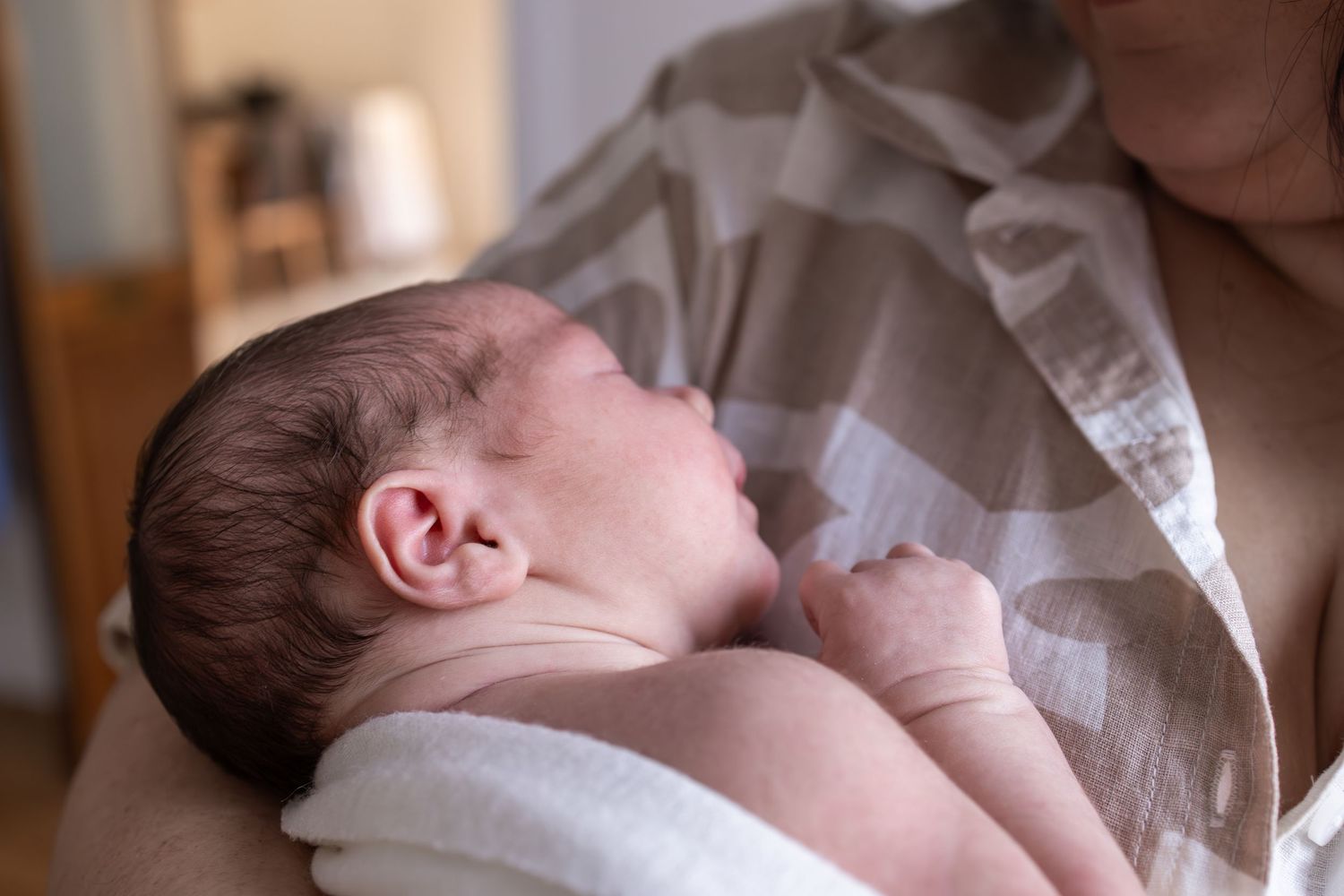 Artistic side profile view of sleeping newborn during professional photo session.