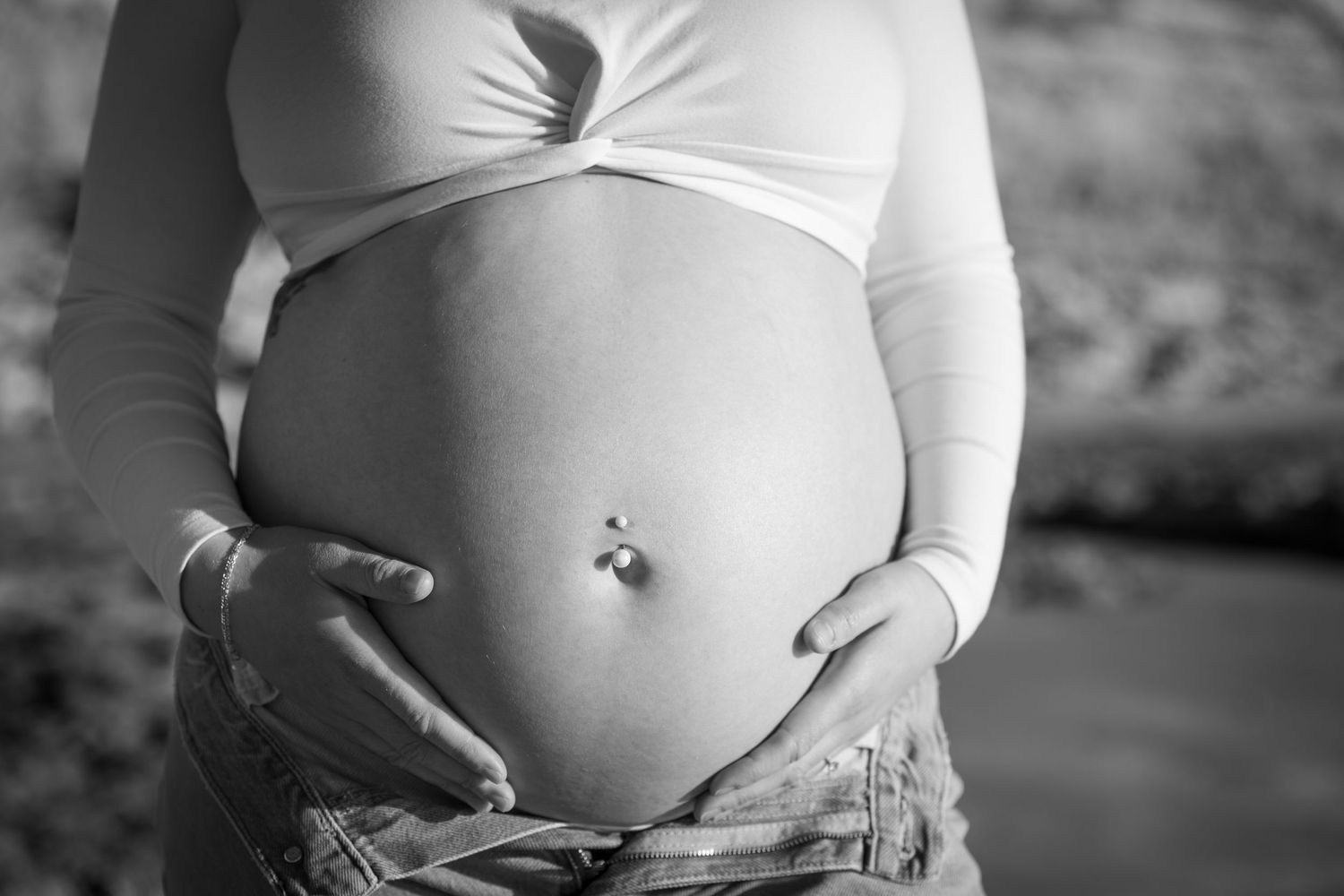Black and white maternity photos showing close-up of pregnant belly.