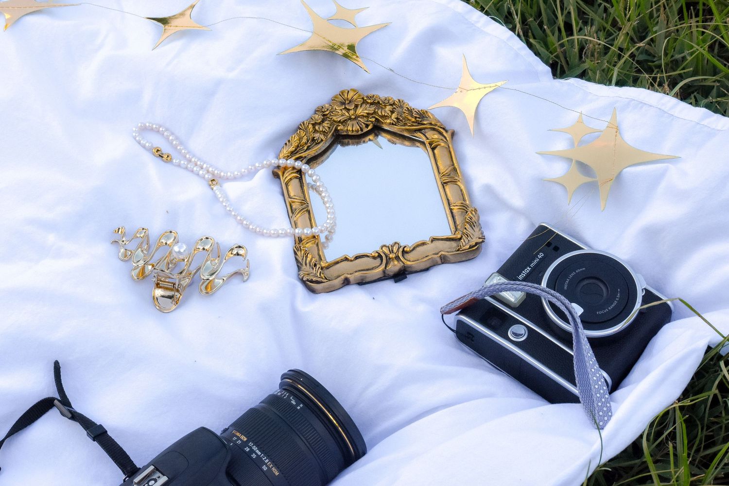 Photography equipment and decorative frame laid out on white fabric with star decorations.