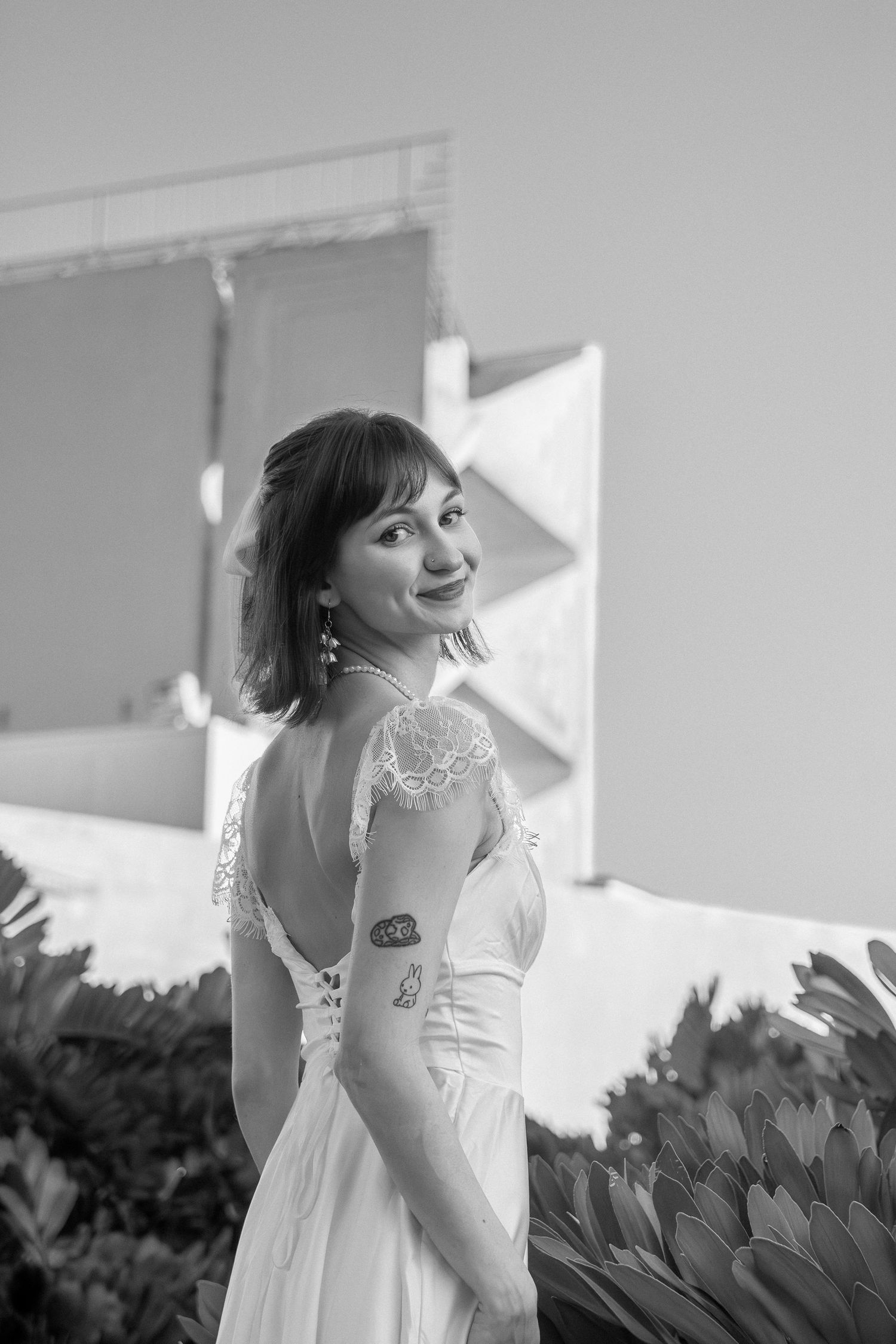 A series of black and white photos showing someone in a white dress posing against a bright window backdrop.
