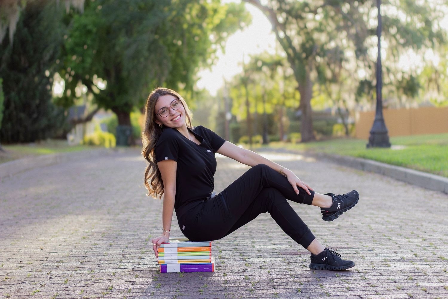 Playful graduation photoshoot on cobblestone path showing creative poses.
