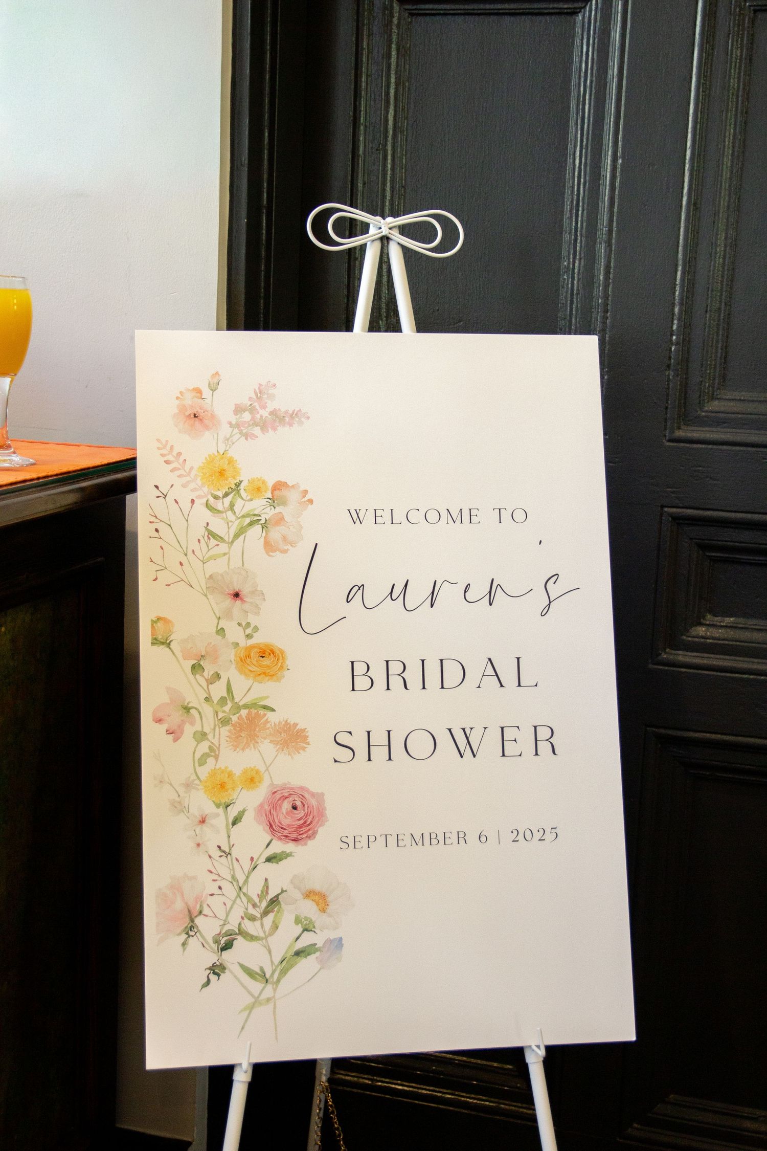Elegant bridal shower welcome sign with delicate watercolor floral designs and calligraphy text on white easels.