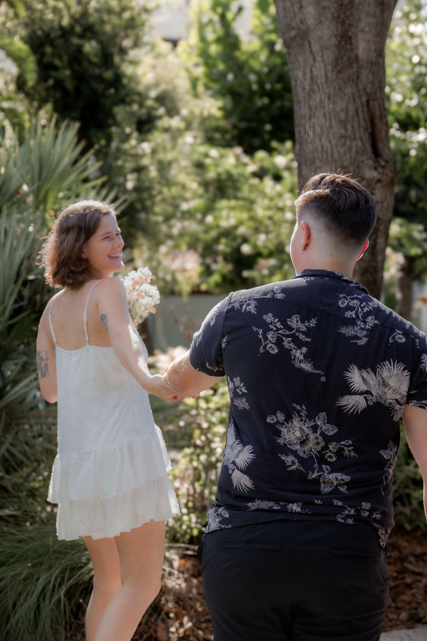 Two people sharing a tender moment in a sunlit garden.
