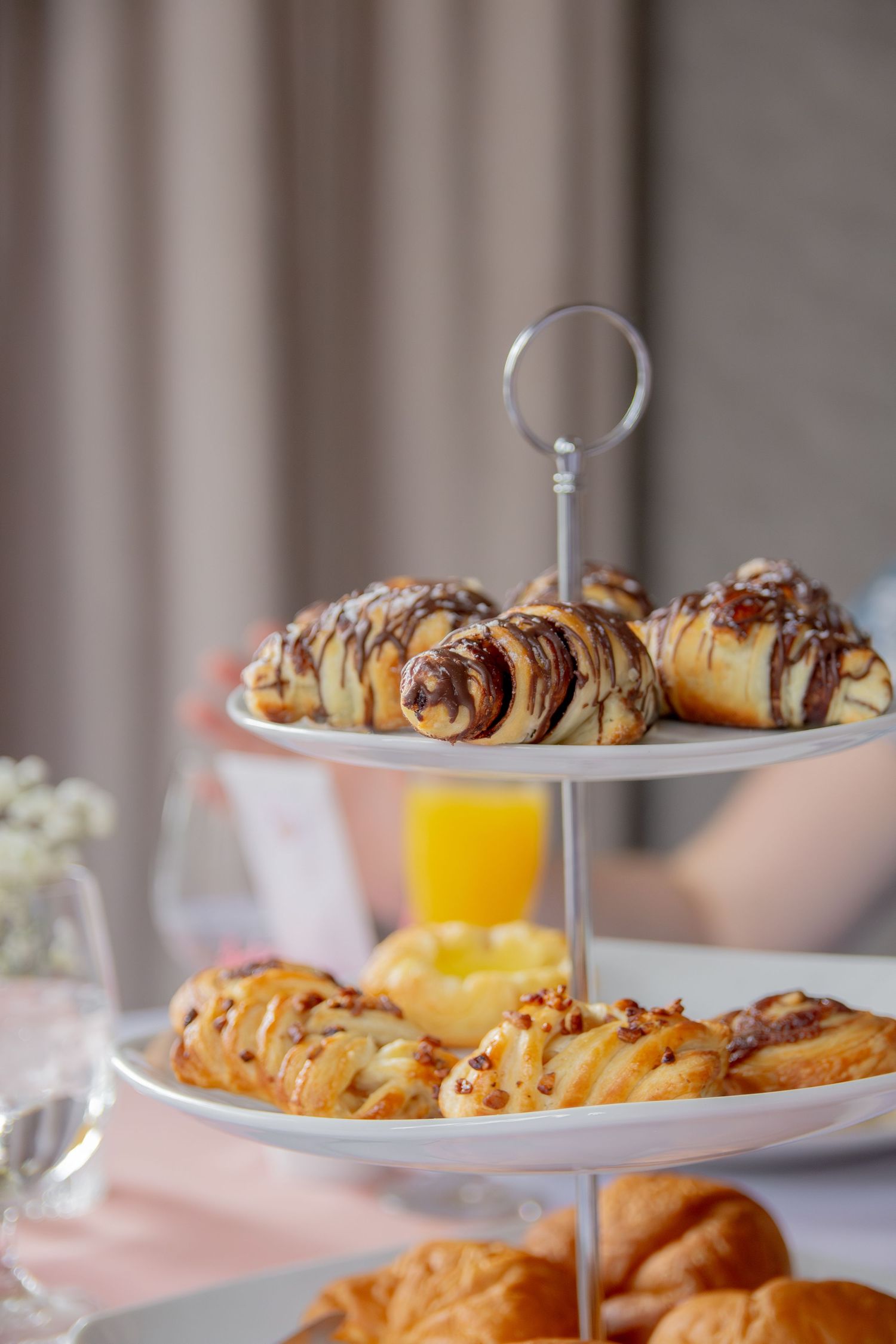Elegant tiered serving plates display fresh pastries and baked goods at a luxurious afternoon tea service.
