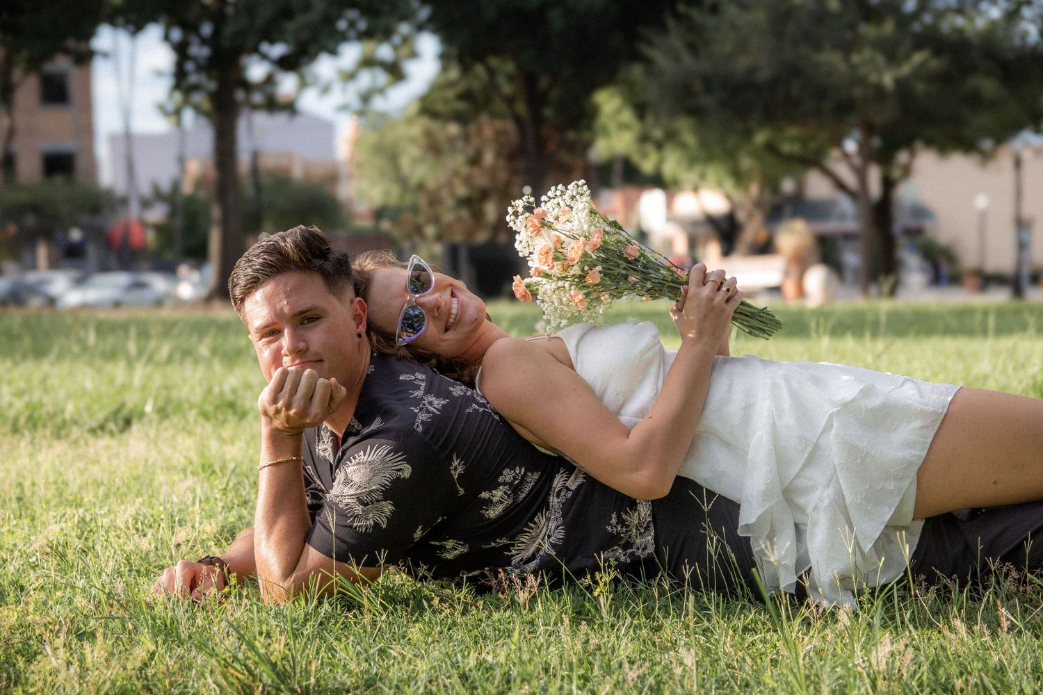 Couple relaxing together on green grass in a park.