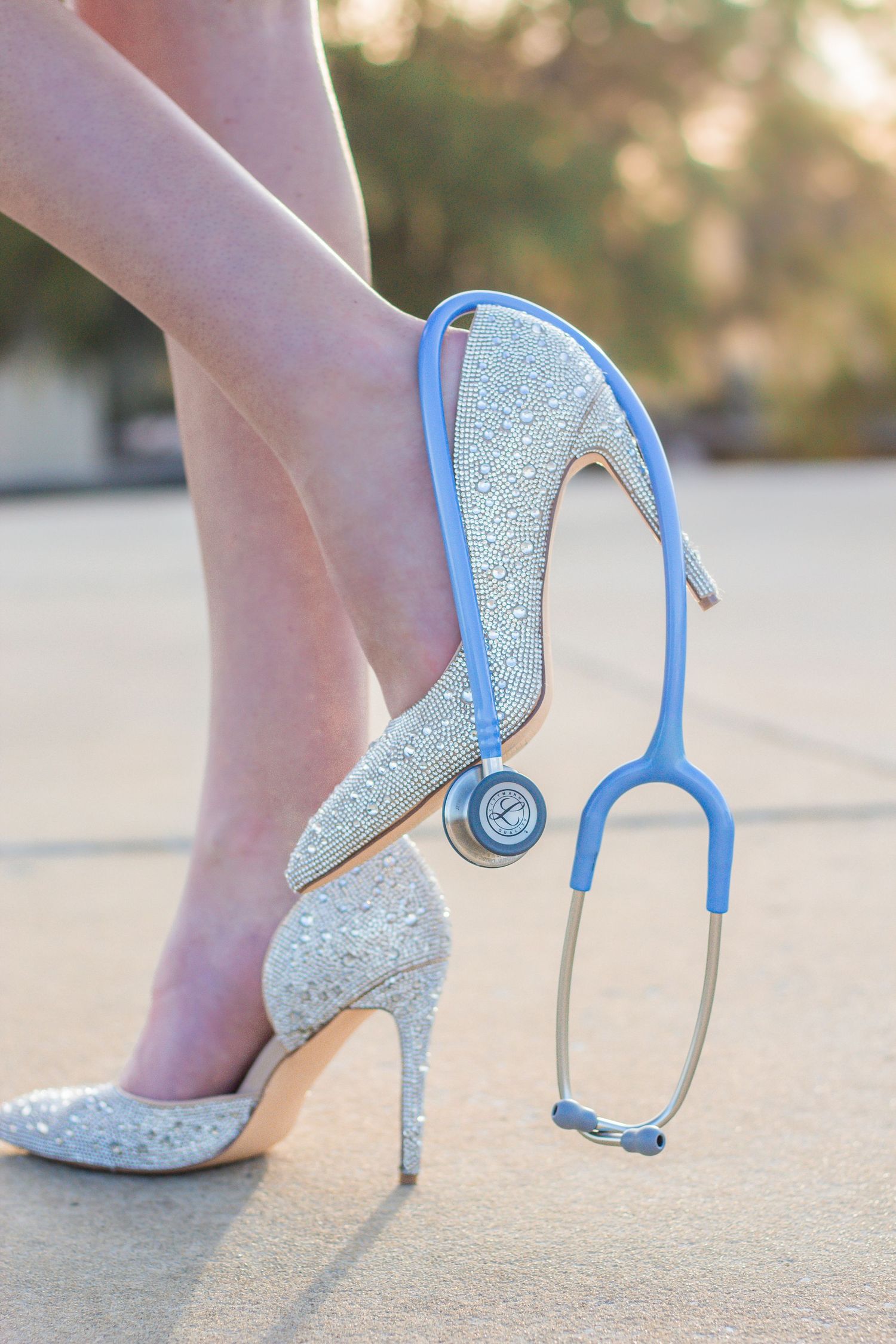 Sparkly white high heels with light blue accents and ankle straps shown from different angles on a concrete surface.