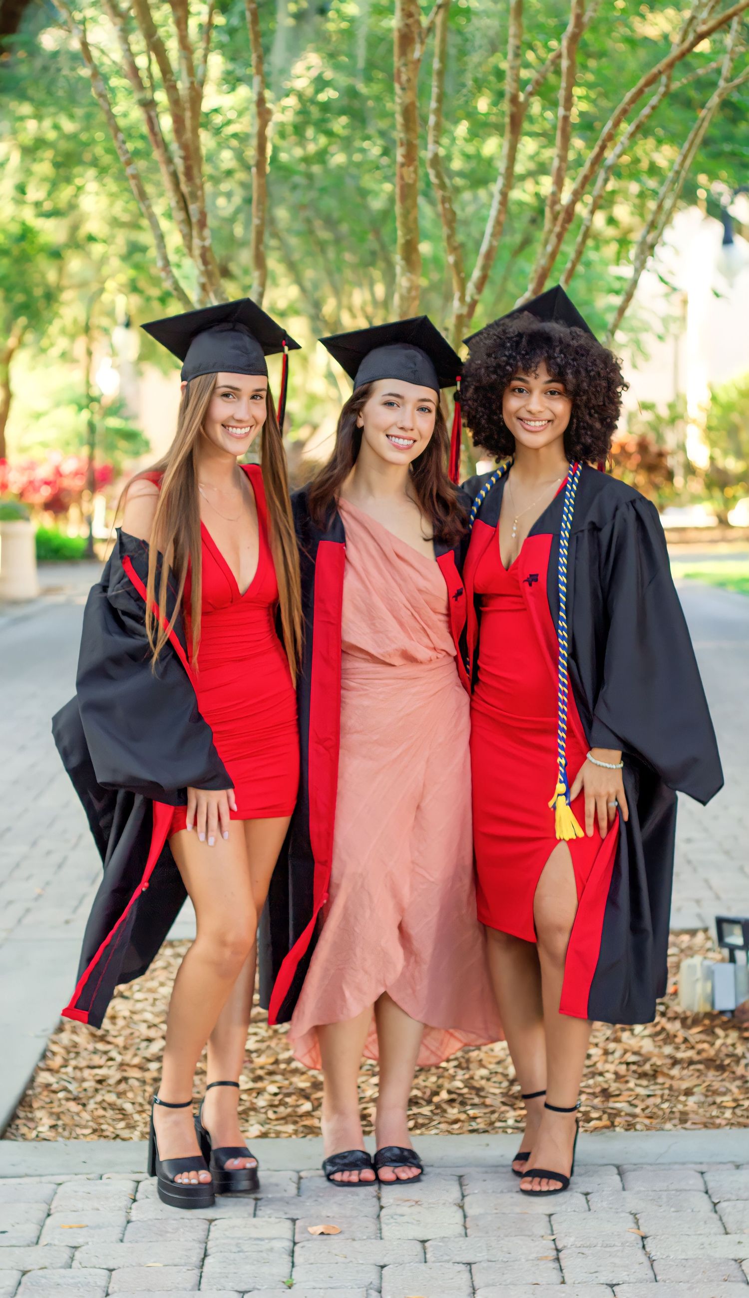 A series of graduation photos showing graduates in red dresses and black gowns posing together outdoors.