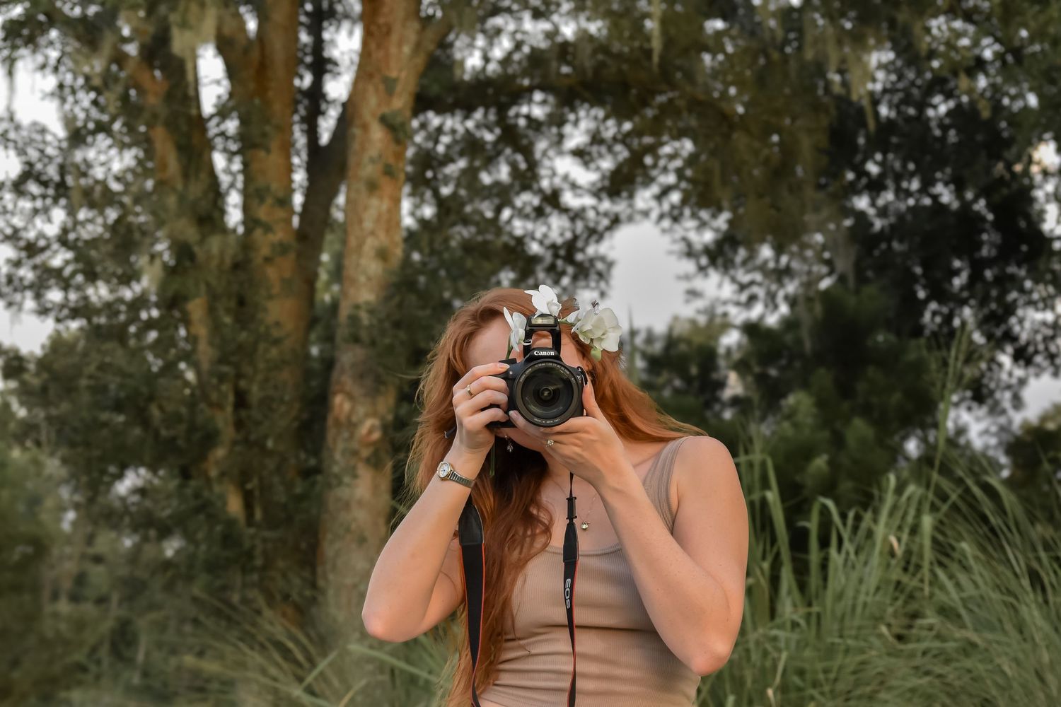 Camera held up against a forest and trees background.