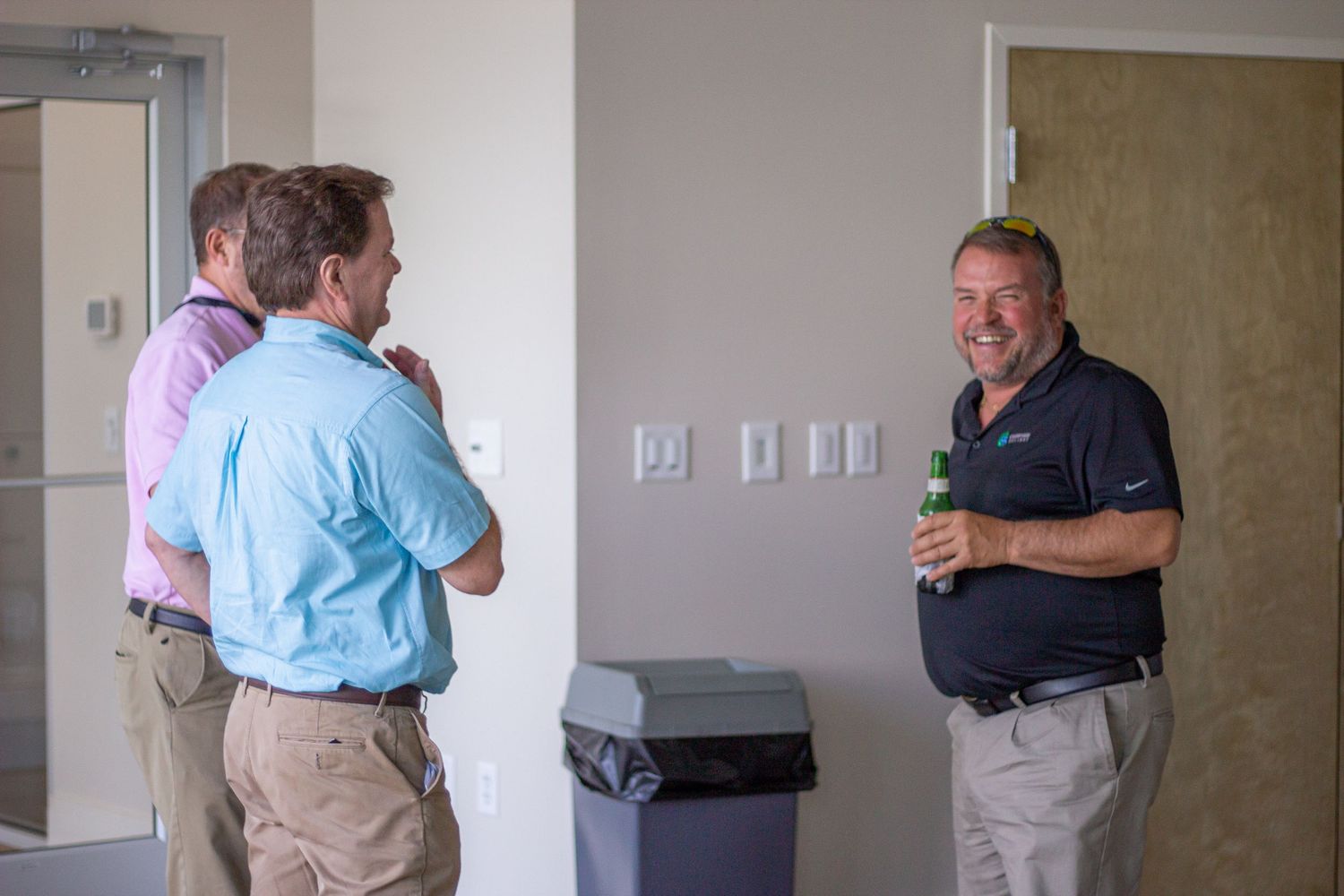 A series of emotional embraces between people in an office or institutional setting showing support and comfort.