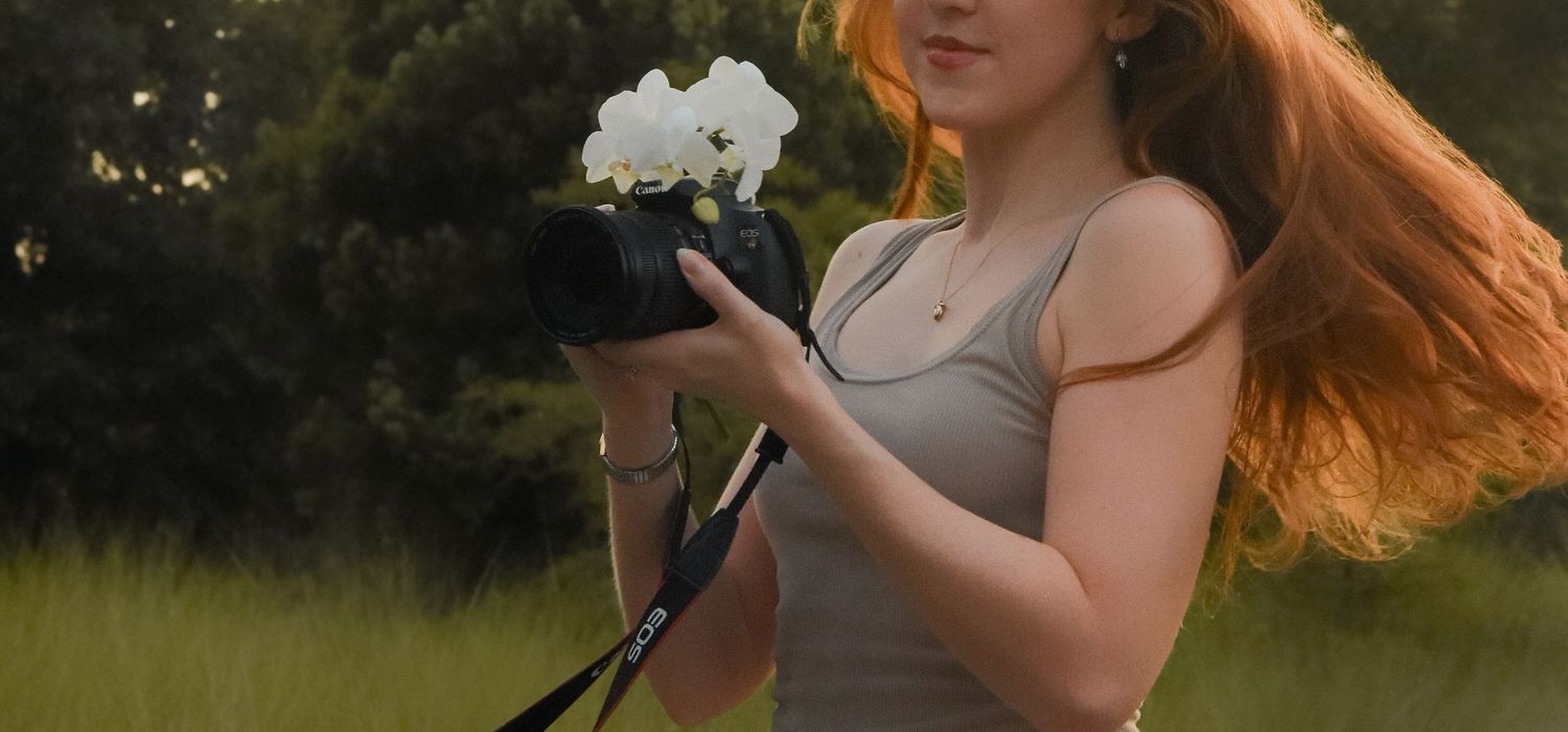 A red-haired woman in casual attire stands outdoors in five sequential poses with flowing hair movement.