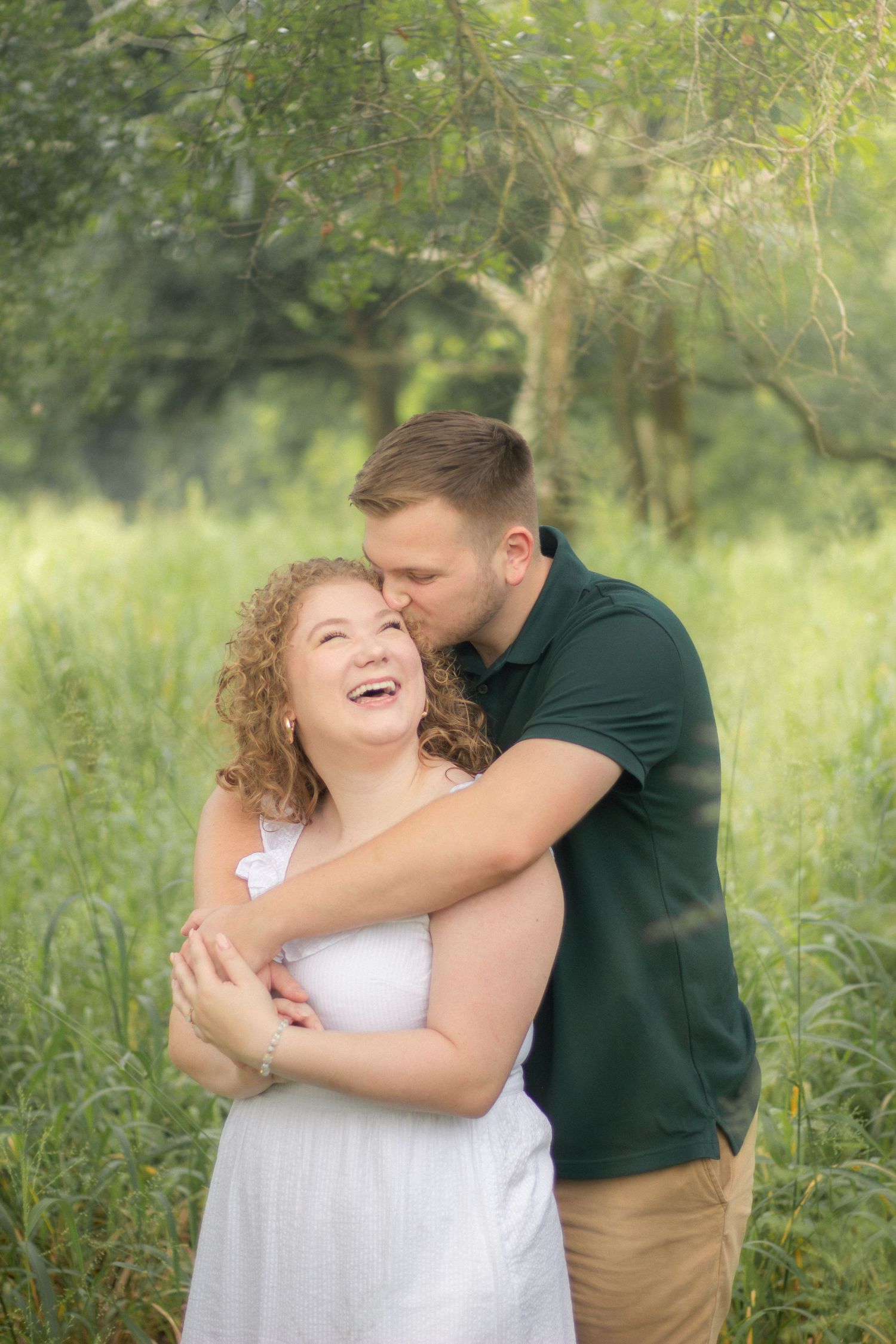 Joyful couple sharing intimate moment in green summer meadow.