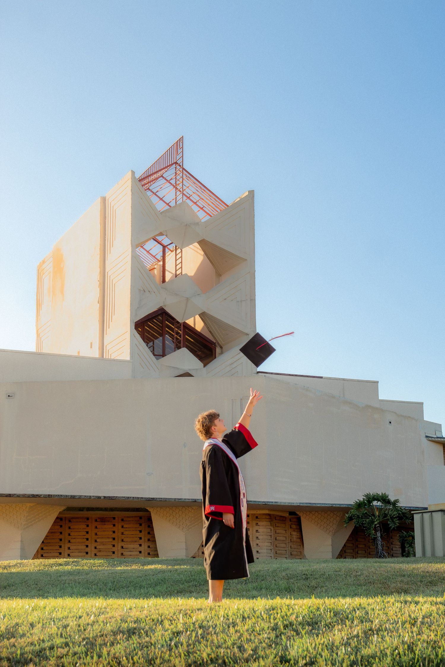 A sequence of photos showing a figure in black and red against a white modern building with geometric shapes and grassy lawn.