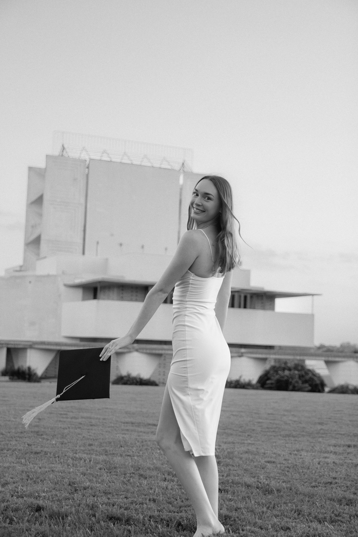 Black and white artistic portrait series in front of modern architectural building.