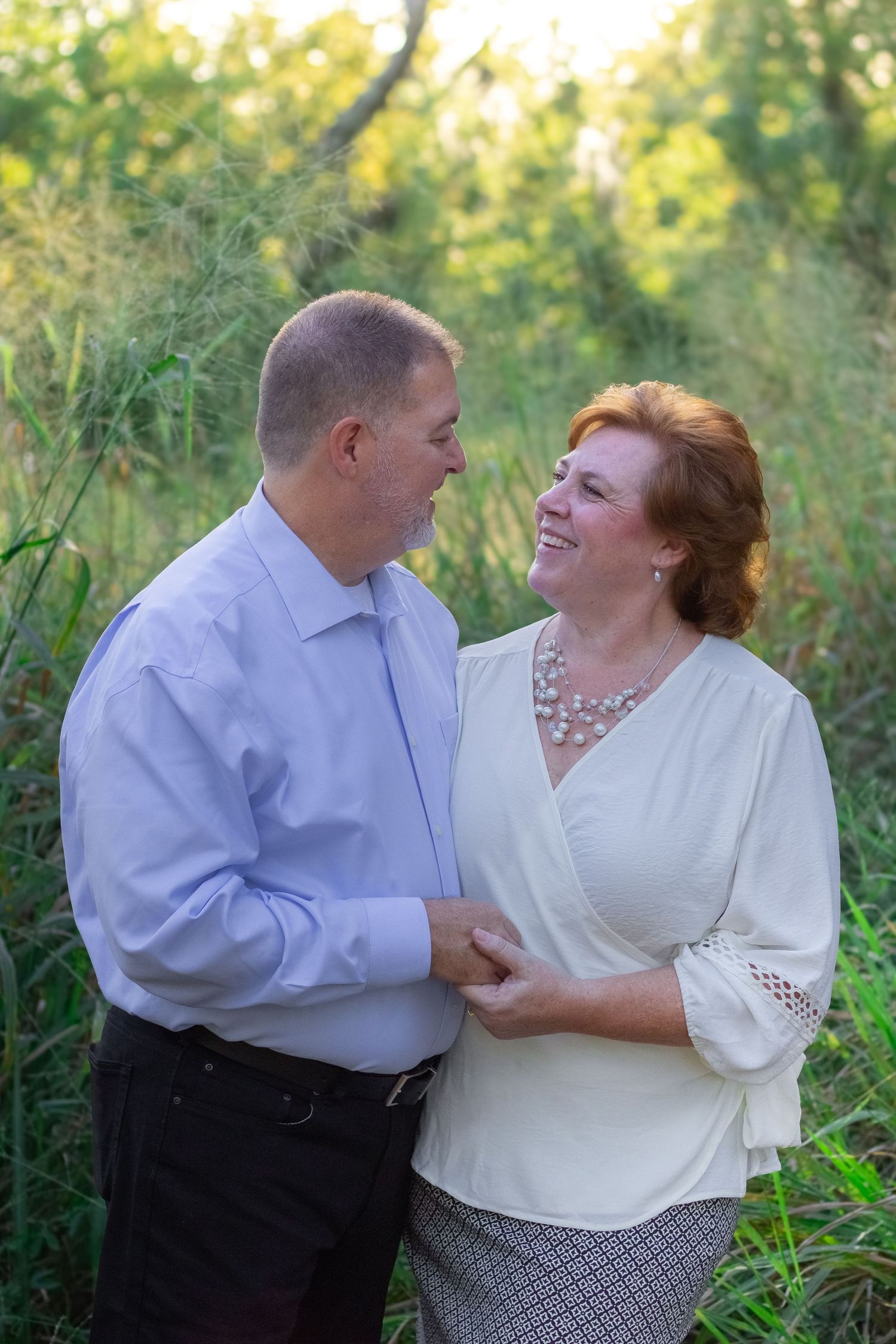 Couple laughing together during outdoor portrait session in natural setting.
