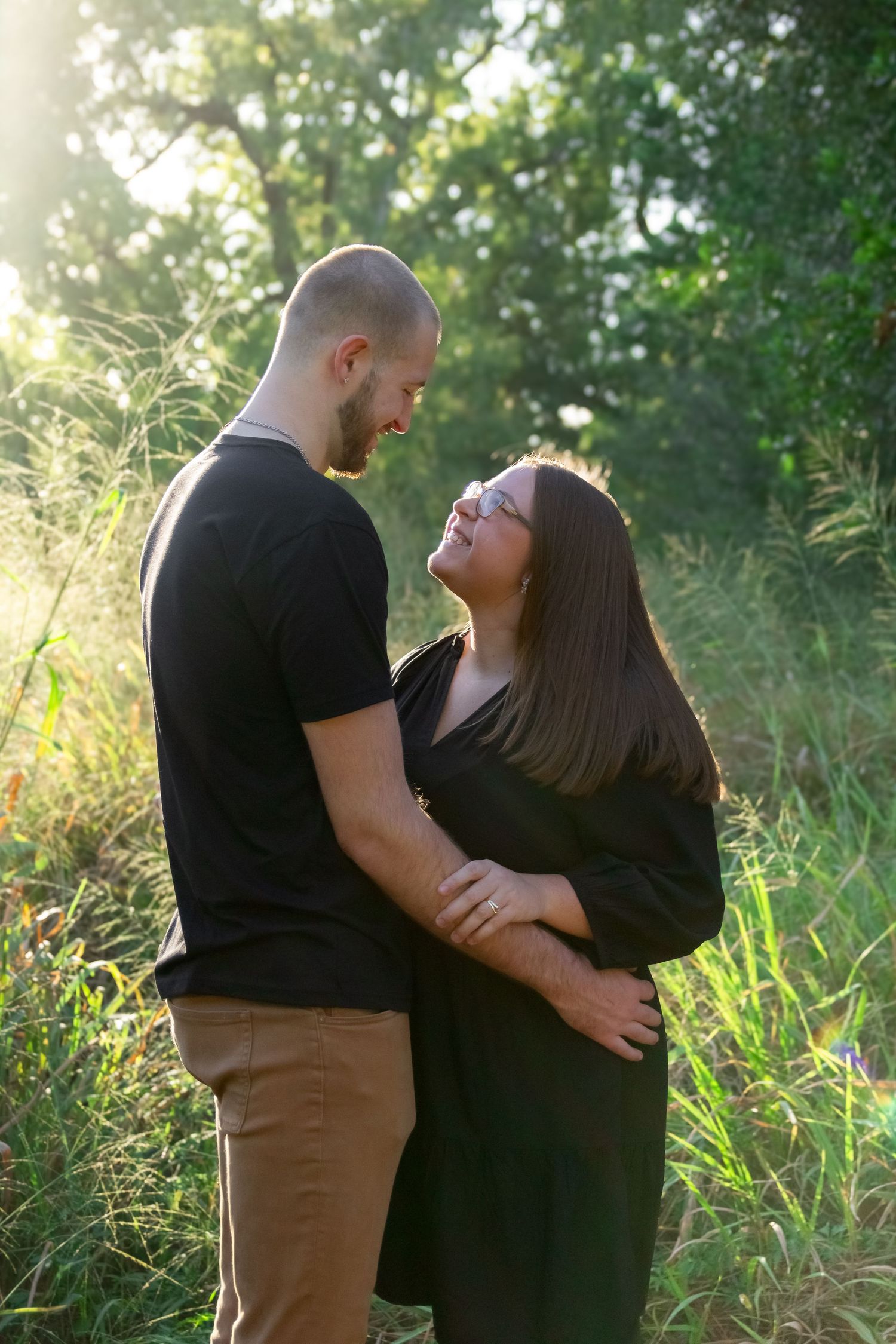 Couple embracing during golden hour engagement photography session.