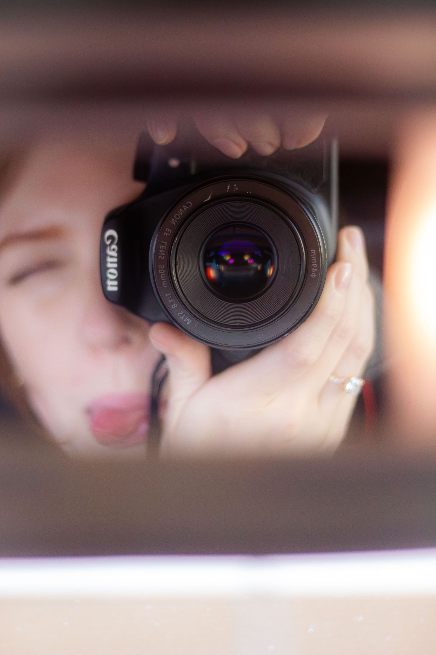 Camera lens filter being attached in a close-up sequence showing hands twisting the filter onto a DSLR camera.