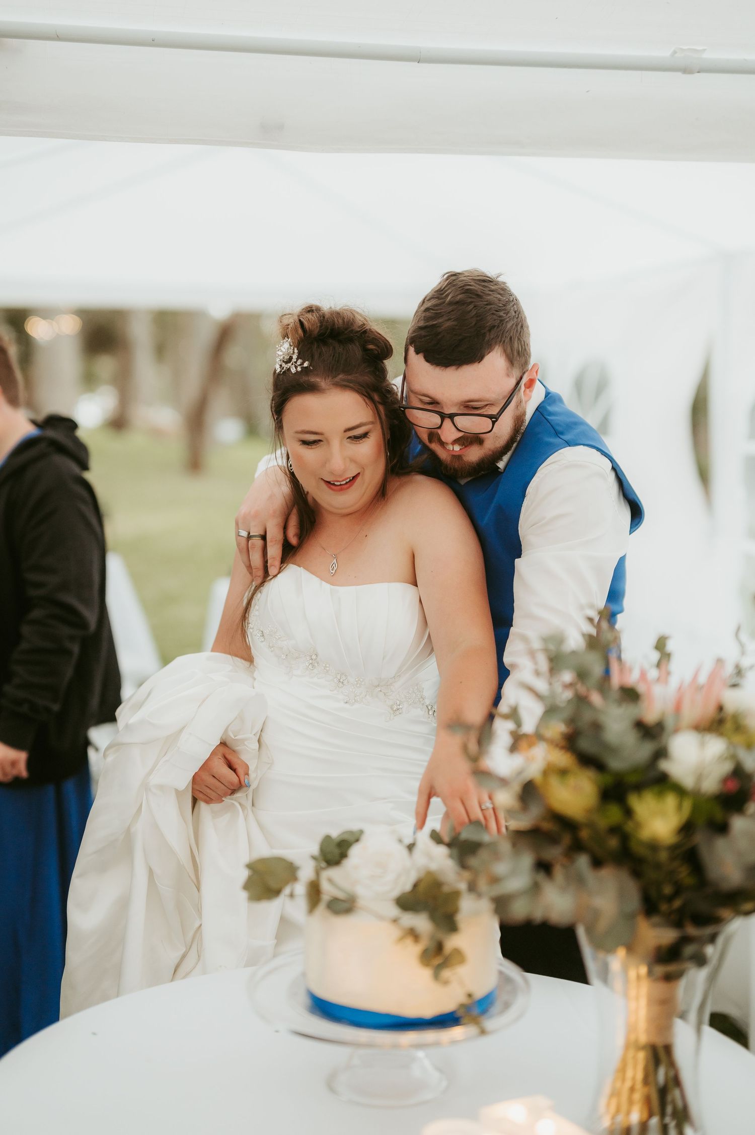 Couple shares intimate moments at their wedding reception table with floral decorations.