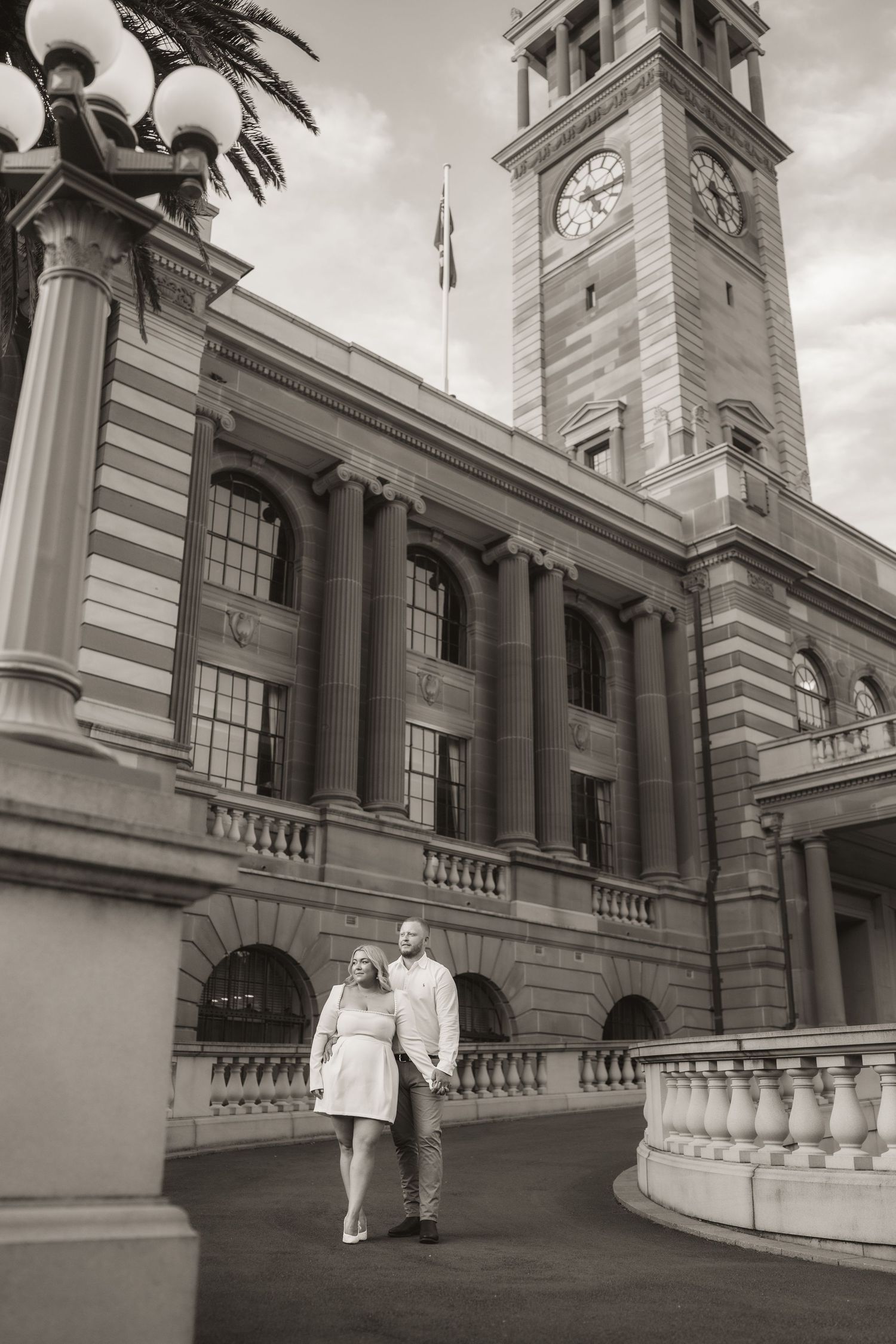 Black and white photo sequence showing couple walking down historic courthouse steps with ornate clock tower architecture.